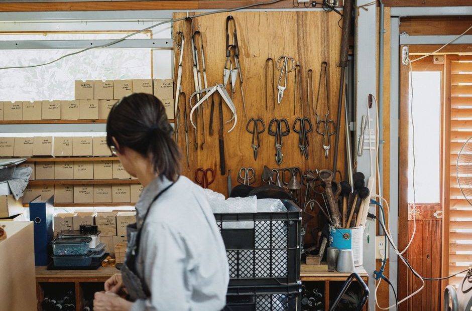 Artisan dans son atelier, outils en main, relisant un document de chantier